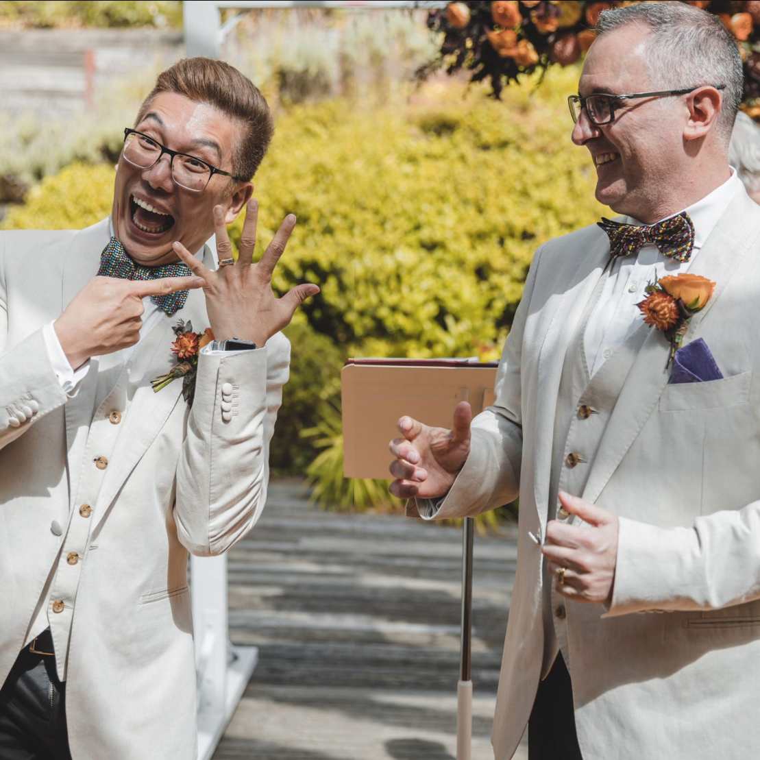 Groom & Groom -groom pointing to ring - we're married!!